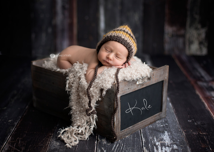 newborn boy in box with bonnet