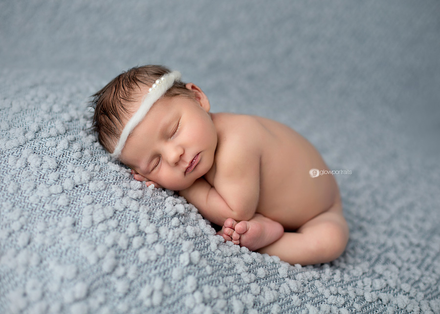 taco pose with newborn girl on blue fabric